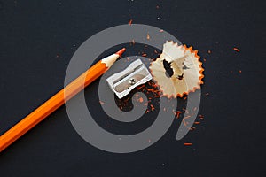 Sharpener and orange pencil on black