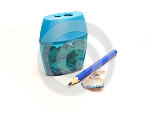 Sharpener and sharpened blue pencil with a shaving