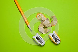 Sharpeners and pencil on green background, close-up