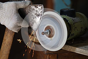 Sharpening an ax on a sharpener close-up