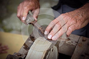 Sharpening knife on old grindstone wheel