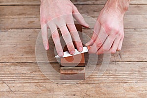 Sharpening the knife with a whetstone on a wooden background. Top view