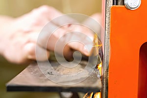 Sharpening throwing knife on a grinding machine