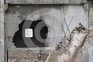 Sharpness on a broken wall. Remnants of the destruction of a large concrete building with a hole in the wall