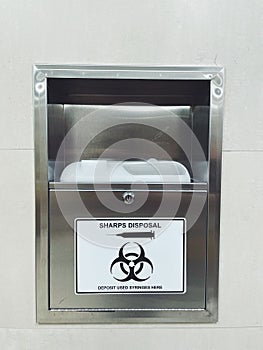 Sharps disposal. Container for disposal of used syringes in a public place.