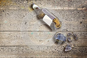 Shattered beer bottle resting on the ground - alcoholism concept