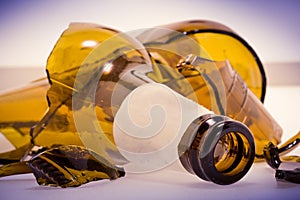 Shattered brown beer bottle isolated on white background - Alcoholism concept