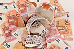 Shattered cup on top of euro bills symbolising economic fallout.