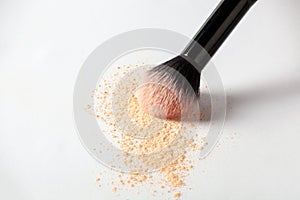 Shattered face powder on white background. Make up powder texture close up. Scattered matte powder