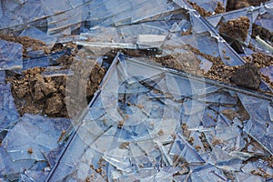 A shattered window on the ground. Broken glass background. Shards