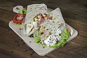 Shaurma chicken roll in a pita with fresh vegetables and cream s