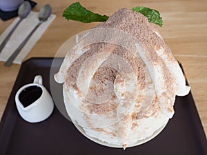 Shaved Ice dessert with cocoa, on Wooden table .