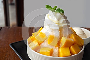 Shaved ice dessert with mango sliced.  Served with vanilla ice cream and whipped cream. Sweet dessert in Korean style. Local name