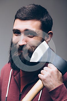 Shaving with axe. Portrait of Confident young bearded man carrying a big axe