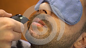 Shaving the beard in a old style barber shop