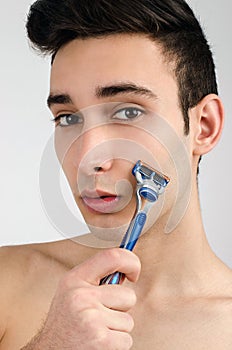 Shaving the beard with a razor.