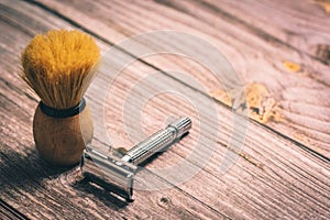 A Shaving brush and double edged razor on a rustic wooden table photo