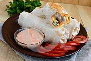 Shawarma - Middle East (Arabic) dish of pita (lavash) stuffed with: grilled meat, sauce, vegetables.