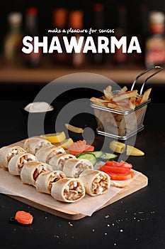 Shawarma slices on cutting wood with fries and pickles