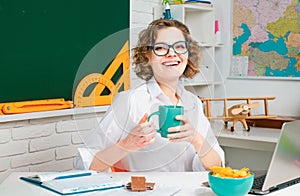 Shcool teacher in class on blackboard background. Professional portrait.