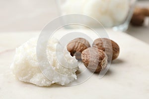 Shea butter and nuts on marble board