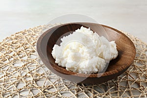 Shea butter in wooden bowl on table