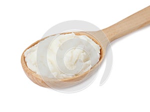 Shea butter in wooden spoon on white