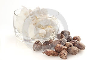 Shea nuts near butter on white background