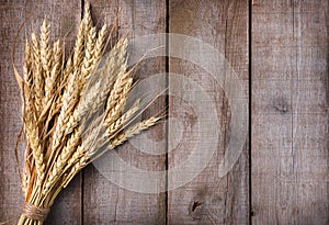 Sheaf of wheat ears on wooden table