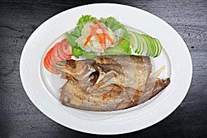 Sheatfishes Fish Fried with crispy garlic on a white plate