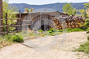 Shed with logs, in New Mexico, tucked away near a mountains shadow