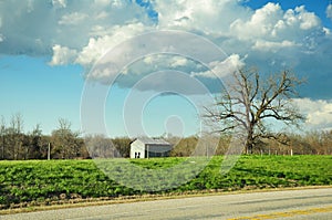 Shed in pasture under cloudy blue sky