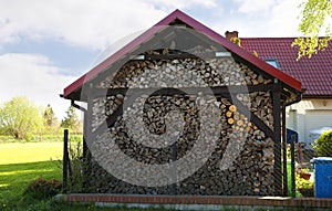 Shed with stacked firewood outdoors on sunny day