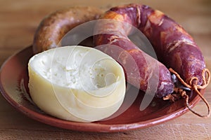 Sheep\'s milk cheese from Azeitao and portuguese smoked sausage on clay plate photo