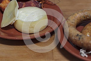 Sheep\'s milk cheese and portuguese smoked sausage on clay plates