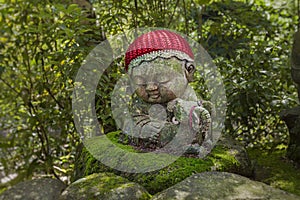 Sheep - symbol of japanese horoscope. Jizo stone statue wearing knitted and cloth hats.