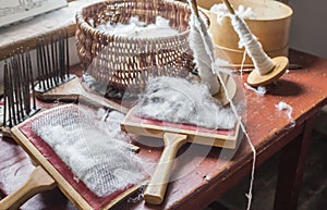 Sheep wool and carding brushes lying on table. photo