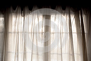 Sheer fabric window curtain with filtered light photo