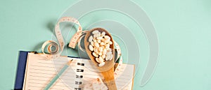 Sheet of Diet Plan and wooden spoon with a measuring tape on a blue background, diet, healthy lifestyle.