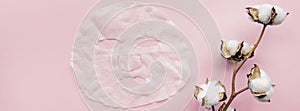 Sheet facial mask and cotton flower on pastel pink paper background. Banner for web design. Skin care, dermatology, beauty concept