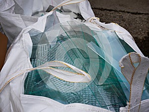 Sheet glass waste in big white plastic bags