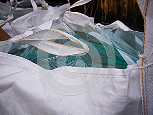Sheet glass waste in big white plastic bags