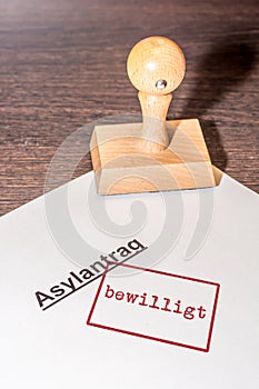 Stamp on white paper with the german words `asylum application granted` photo