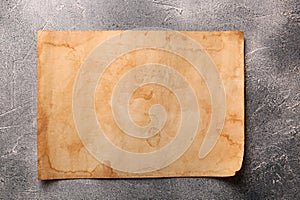 Sheet of old parchment paper on gray textured table, top view