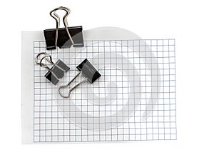 A sheet of paper in a cage for notes with a paper clip on a white background. Entries. Notes. Reminder