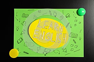 Sheet of paper with phrase Learn English on blackboard, closeup