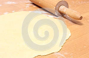 Sheeted yeast cake and rolling pin on wooden table