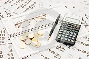 Sheets of a calendar with coins and a notebook