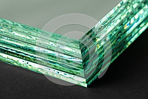 Sheets of Factory manufacturing tempered clear float glass panels cut to size. Dark background