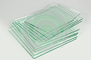 Sheets of Factory manufacturing tempered clear float glass panels cut to size. White background